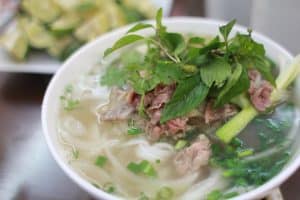 a bowl of pho bo, rice noodle soup with beef