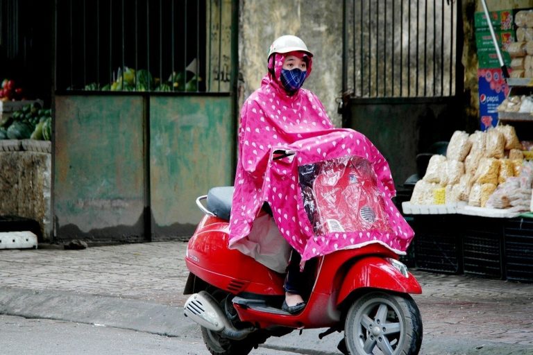 a local woman riding in the rain in North Vietnam