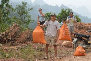 a farmer carrying two heavy bags in Pu Luong National Park