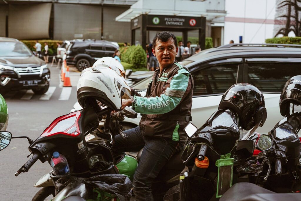 Grab driver taking off his motorbike helmet