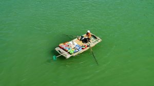 a woman selling snacks from a little boat in Ha Long Bay, North Vietnam