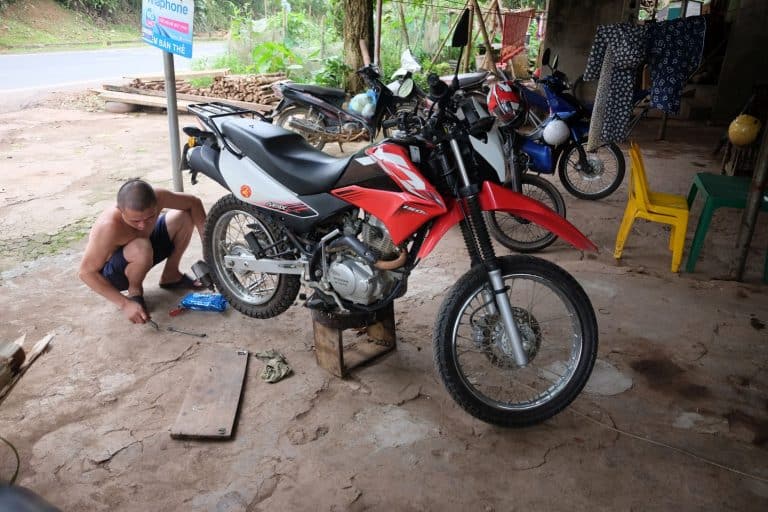 a local mechanic removing the rear tyre from a Honda XR 150
