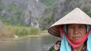 a portrait of a boat woman in van long nature reserve
