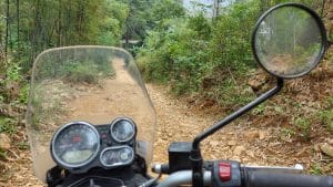 View of a small dirt road from the seat of a royal enfield himalayan