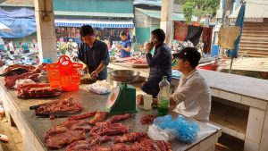 the local butcher hard at work in bao lac open air market ha giang