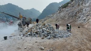 female road construction workers in a small roadside quarry