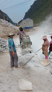 road construction workers grinding stone in a roadside quarry