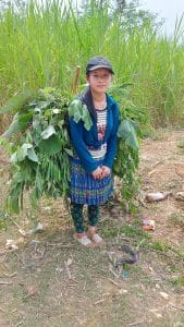 young hmong girl on her way home from working in the fields