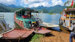 putting motorcycles onto the ferry across the Black River, north Vietnam
