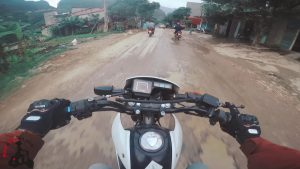 Riding a Honda XR125 through a small town in Ha Giang