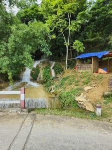 a small waterfall near a cafe on the pu luong road