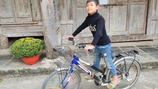 a young local cycling his bike int he grounds of a pagoda in Huu Lung, Lang Son