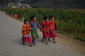 some children strolling down the street in lung cu, ha giang