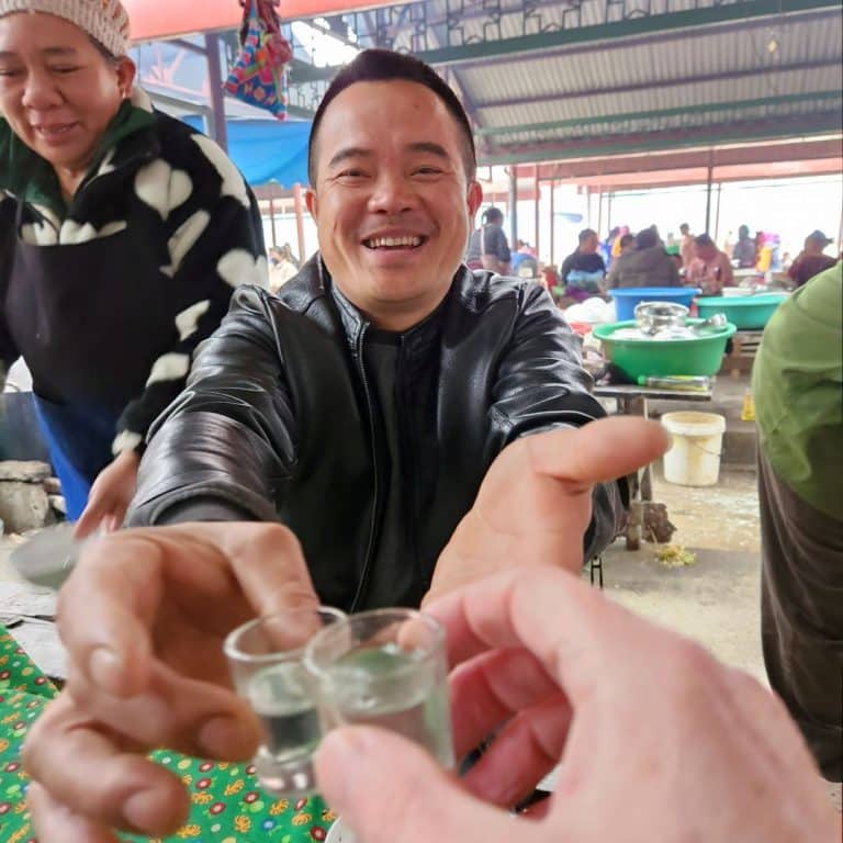rice wine with a local in sin cheng market, lao cai