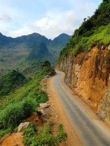 A small winding road cut from the mountainside in Ha Giang
