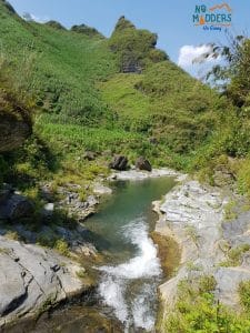 a small hidden waterfall in the ha giang countryside