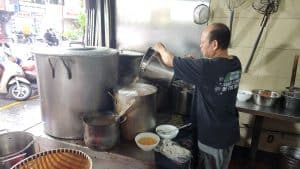A server adding more broth to the pot in a local Pho shop.