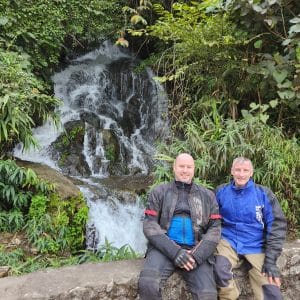 Tim and Dan by a waterfall when riding the Cao Bang Loop