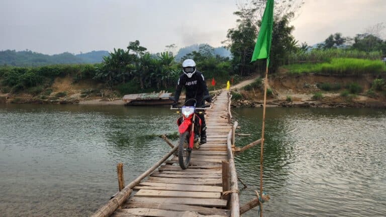 Tom takes his Honda CRF300L over a rickety wooden bridge in Yen Bai province.