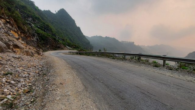 a sweeping downhill stretch of newly built road in Lung Tam, Ha Giang