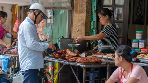 a man buying roast pork in Hanoi's Old Quarter